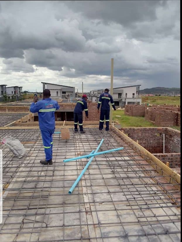 Harare Plumbing Solutions team setting out blue PPR supply pipework through the reinforcing mesh of a new build slab